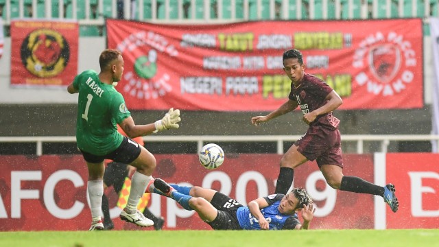 Pemain PSM Makassar M Rahmat (kanan) menendang bola ke arah gawang Home United pada penyisihan Grup H Piala AFC di Stadion Pakansari, Bogor, Jawa Barat, Kamis (30/4). Foto: ANTARA FOTO/Hafidz Mubarak A