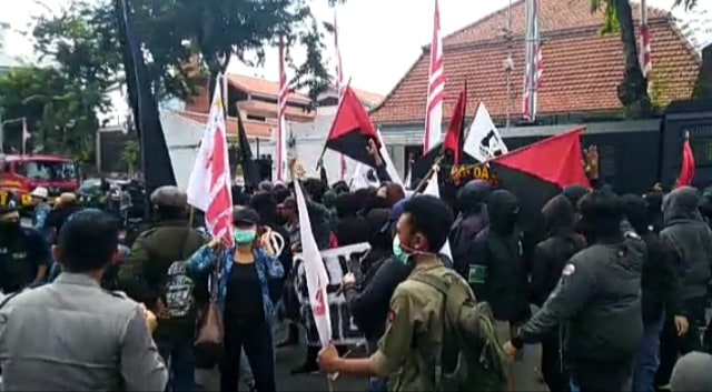 Massa berseragam hitam ricuh di depan Gedung Negara Grahadi. Foto: Yuana Fatwalloh/kumparan
