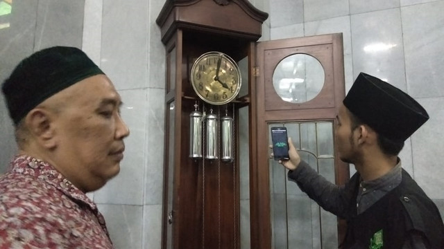 Sejumlah petugas dari UIN Walisongo saat mengecek ulang ketepatan jarum jam yang ada di Masjid Kauman. Foto: Afiati Tsalitsati/kumparan