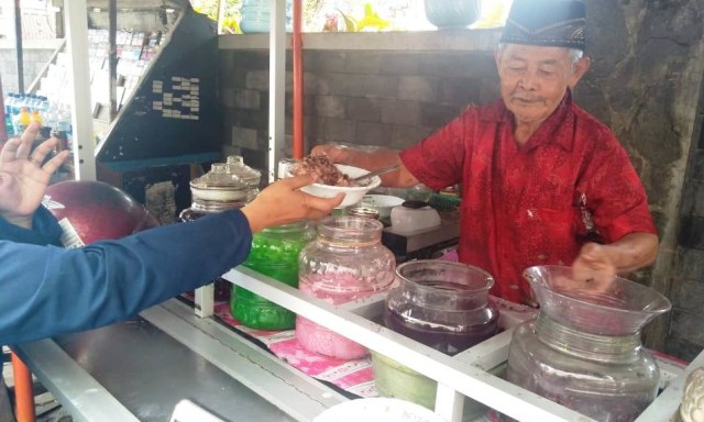 Mohammad Said saat melayani pembeli di gerobak es campurnya. 