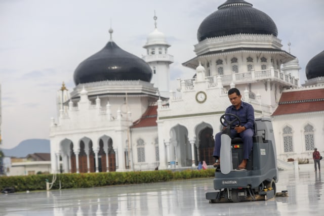 Pekerja mengepel lantai Masjid Raya Baiturrahman, Banda Aceh. Foto: Suparta/acehkini   