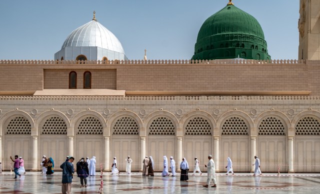 Pengunjung berjalan dengan latar kubah hijau yang menjadi lokasi makam Nabi Muhammad SAW, Abu Bakar as Siddiq, dan Umar bin Kattab di Masjid Nabawi, Madinah, Arab Saudi, Senin (6/5). Foto: ANTARA FOTO/Aji Styawan