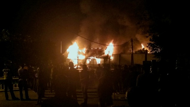 Warga menyaksikan Rutan Negara Klas IIB Siak Sri Indrapura terbakar di Kabupaten Siak, Riau, Sabtu (11/5). Foto: Antara/Bayu Agustari Adha