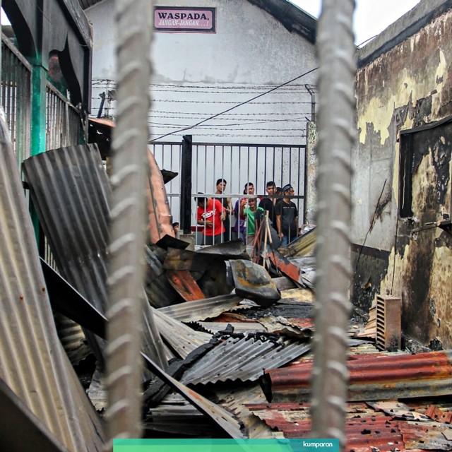 Sejumlah narapidana berada di dekat puing bangunan Rutan yang hangus terbakar pasca kerusuhan di Rutan Kelas II B Siak Sri Indrapura. Foto: Antara/Rony Muharrman
