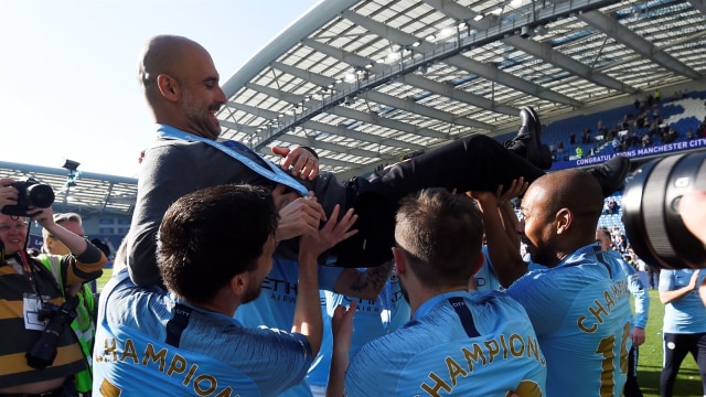 Pep Guardiola diarak oleh pemain-pemainnya sendiri. Foto: Toby Melville/Reuters