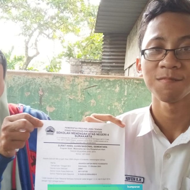 Ananda Hafidh Rifai Kusnanto menunjukkan nilai UNBK nya bersama ibunya. Foto: kumparan