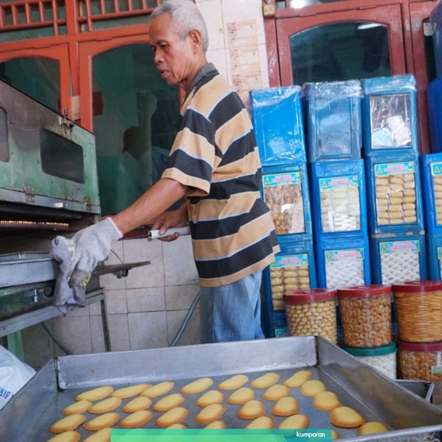 Seorang pekerja memasukkan adonan kue kering ke dalam oven di industri rumahan Butter Cookies Kwitang, Jakarta Pusat, Rabu, (15/5). Foto: Jamal Ramadhan/kumparan