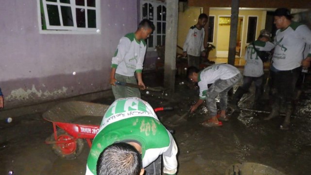 Ilusrasi Anggota FPI membersihkan lumpur sisa banjir. Foto: Twitter/@FPI_isback