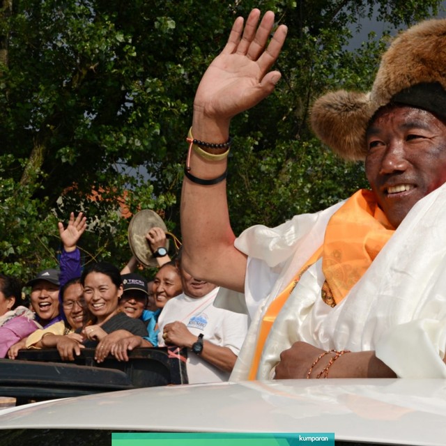 Pendaki gunung Everest, Kami Rita Sherpa melambaikan tangan saat tiba di bandara Tribhuvan. Foto: AFP/Prakash MATHEMA