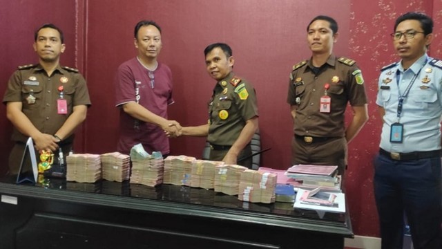 Terpidana Jaury O Sakung bersalaman dengan Kepala Kejaksaan Negeri (Kajari) Palu, usai penyerahan uang kerugian negara di Kejari Palu, Rabu, (15/5), Foto: Ikram/PaluPoso