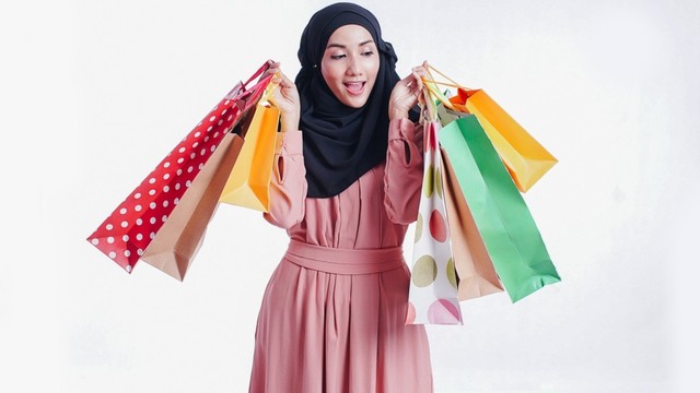 Seorang wanita membawa tas belanja oleh-oleh. Foto: Shutter Stock
