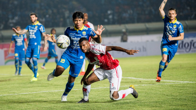 Pesepakbola Persib Bandung Achmad Jufriyanto berebut bola dengan pesepakbola Persipura Jayapura Marinus Mariyanto Wanewar. Foto: Antara/M Agung Rajasa