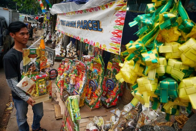 Seorang pedagang parcel lebaran merapikan parcel miliknya di dekat Stasiun Cikini, Jakarta Pusat, Jakarta, (19/5). Foto: Jamal Ramadhan/kumparan