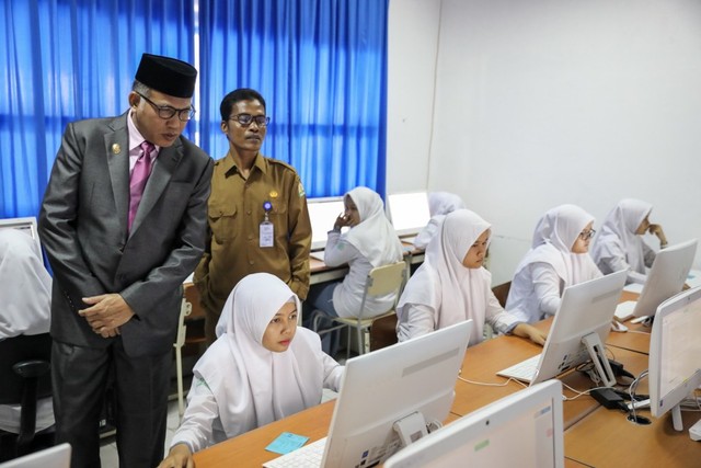 Plt Gubernur Aceh Nova Iriansyah bersama Kepala Dinas Pendidikan Aceh Syaridin meninjau pelaksanaan UNBK SMA sederajat di Banda Aceh. Foto: Suparta/acehkini