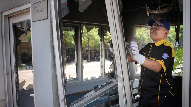 Anggota polisi lalu lintas membongkar jendela Pos Polisi Sarinah yang rusak, Jakarta, Kamis (23/5). Foto: Jamal Ramadhan/kumparan