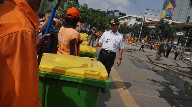 Gubernur DKI Jakarta, Anies Baswedan turut membersihan jalan di perempatan sarinah pasca aksi 22 Mei. Foto: Irfan Saputra/kumparan