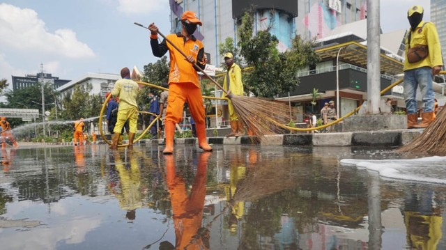 Petugas kebersihan membersihkan jalan di perempatan sarinah pasca aksi 22 Mei. Foto: Irfan Saputra/kumparan