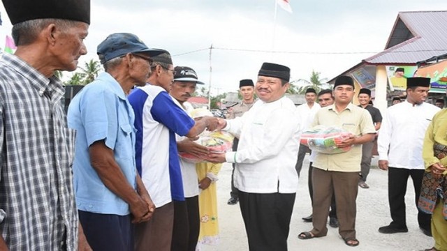 BUPATI Bengkalis, Amril Mukminin (kopiah hitam) saat membagikan sembako murah ke warga, belum lama ini. 