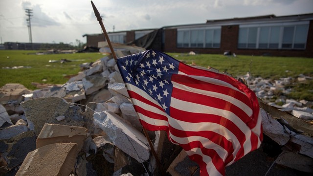 Sebuah bendera Amerika Serikat saat tornado menghantam sekolah di Ohio. Foto: AFP/SETH HERALD