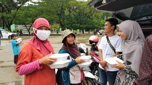 Tim SIC turut membantu membagikan makanan kepada para pumulung di pelataran Tugur Religi, Kota Kendari, Sabtu (1/6). Foto: Attamimi/kendarinesia