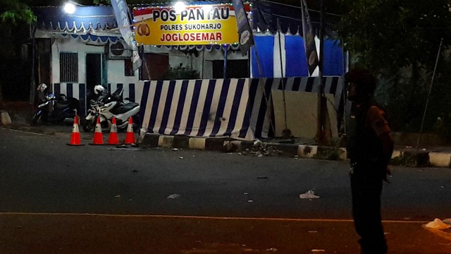 Seorang anggota kepolisian menjaga lokasi kejadian ledakan di Pos Pantau Arus Mudik Joglosemar, Kartasura, Sukoharjo, Jawa Tengah, Selasa (4/6). Foto: ANTARA FOTO/Aloysius Jarot Nugroho