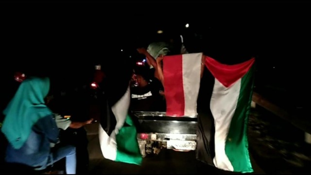 Warga membawa benderah Palestina saat malam takbiran di Kota Sorong. Foto: Jeje/balleo-kumparan