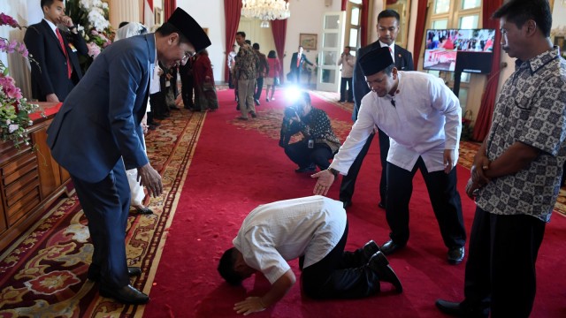 Seorang warga bersujud di depan Presiden Joko Widodo saat halalbihalal di Istana Negara, Jakarta, Rabu (5/6). Foto: ANTARA FOTO/Puspa Perwitasari