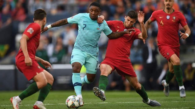 Ruben Dias (kanan) saat berduel dengan pemain Belanda, Steven Bergwijn, di final UEFA Nations League. Foto: PATRICIA DE MELO MOREIRA / AFP
