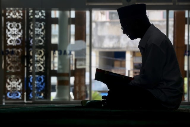 Seseorang membaca Alquran sambil beriktikaf di Masjid Raya Baiturrahman, Rabu (8/5). Foto: Suparta/acehkini