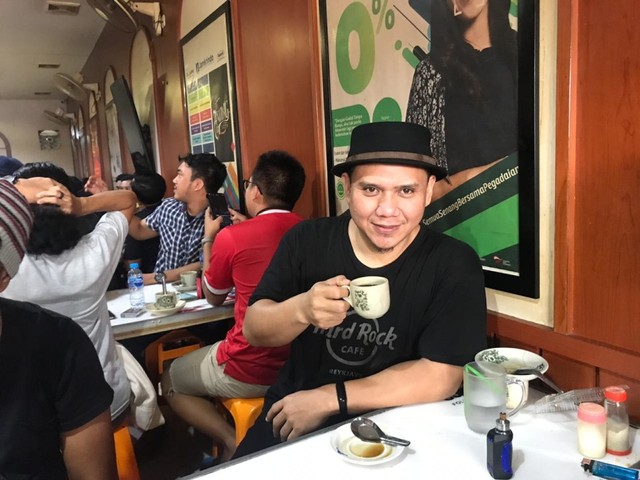Fadly menyicipi kopi hitam di warkop Asiang, Pontianak. Foto: Teri