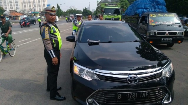 Polisi tindak pengemudi yang pasang lampu rotator Foto: Raga Iman/kumparan
