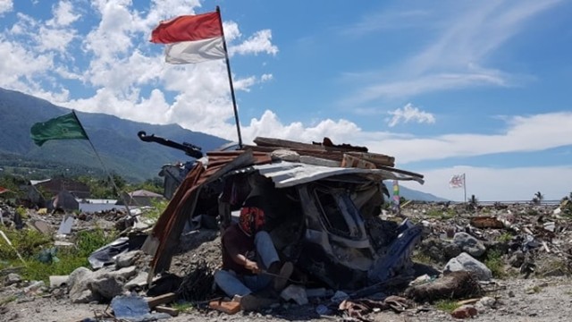 Salah satu warga sedang memotong besi di lokasi likuefaksi Perumnas Balaroa Palu, Sabtu (6/4). Foto: Dok. PaluPoso