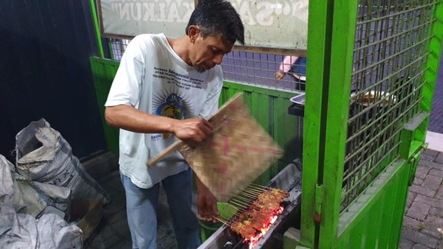 Adik Sujito sedang membakar sate kalkun. Foto: Prameshwari 'Imesh' Sugiri/kumparan