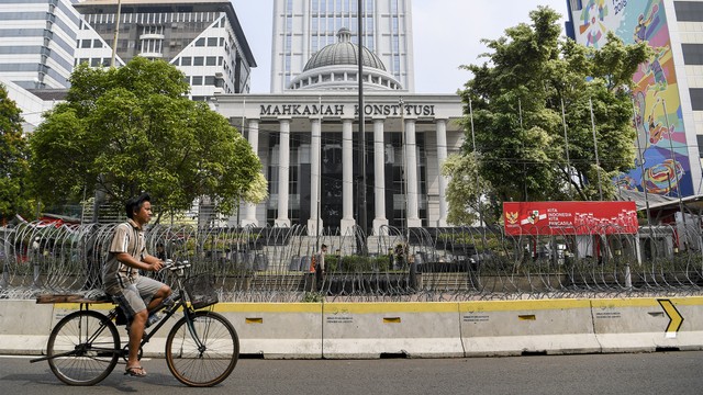 Pengendara sepeda melintas di depan Gedung Mahkamah Konstitusi. Foto: ANTARA FOTO/Hafidz Mubarak A