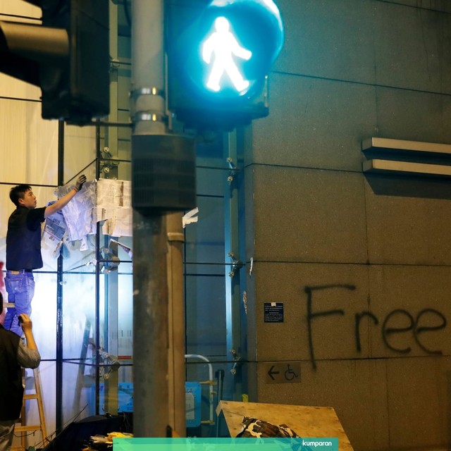 Polisi anti huru hara membersihkan barikade yang didirikan oleh pengunjuk rasa di luar markas polisi, di Hong Kong, China, Kamis (27/6). Foto: REUTERS/Tyrone Siu