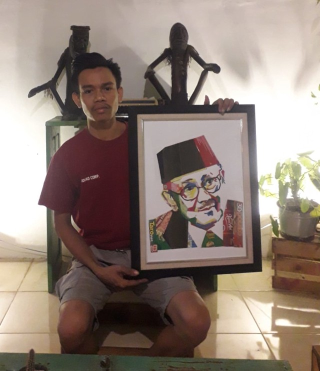 Akhmad Umar (26) menunjukkan karya lukisan berbahan plastik. (Foto: Dok. Pribadi).  
