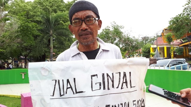 Ely saat membawa poster menjual ginjal untuk biaya pengobatan anaknya