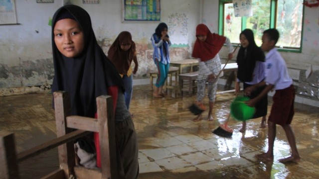 Murid SD Negeri 1 Praja Taman Sari membersihkan kelas setelah diterjang banjir bandang. Foto: Lukman Budianto/kendarinesia.