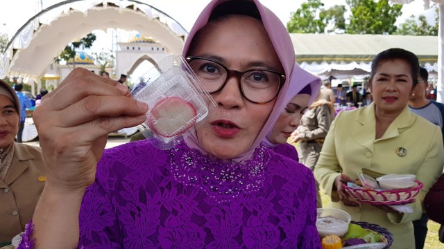 Ketua PKK Sukamara Siti Zulaiha Windu saat memperlihatkan kuliner kerupuk basah khas Sukamara saat pesta rakyat Hari Jadi ke 17 Sukamara di Lapangan Mini Sukamara. (Foto: Joko Hardyono)