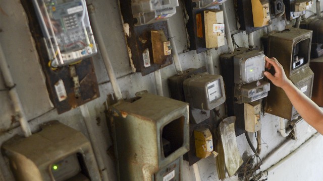 Warga memeriksa meteran listrik. Foto: ANTARA FOTO/Nova Wahyudi