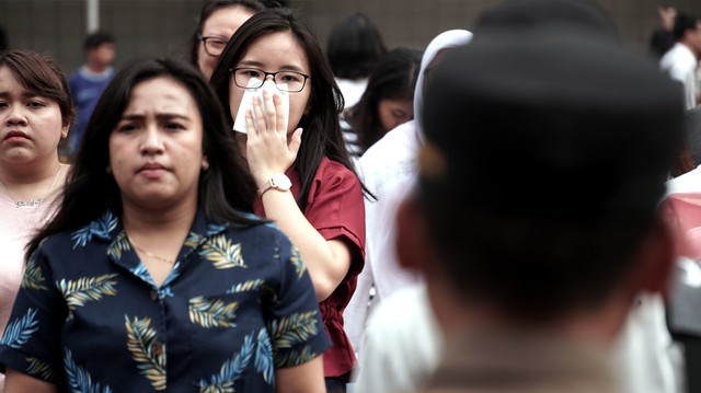 Seorang pejalan kaki yang terlihat menggunakan tisu sebagai pengganti masker saat menyeberang jalan di kawasan Jakarta. Foto: Iqbal Firdaus/kumparan