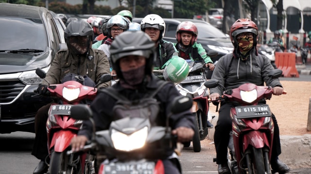 Beberapa pengendara motor yang menggunakan masker dan beberapa lagi tidak menggunakan masker saat berkendara, di kawasan Jakarta. Foto: Iqbal Firdaus/kumparan