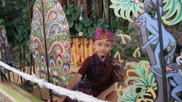 Dalang cilik Putu Adhyaksa Narendra saat tanpil di Festival tepi Sawah , Sabtu (6/7) - kanalbali/GAN