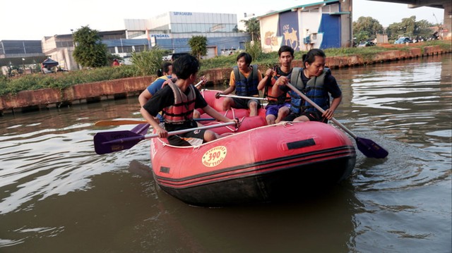 Warga yang menaiki perahu karet di Kalimalang. Foto: Iqbal Firdaus/kumparan