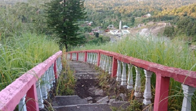 Akses jalan di lokasi wisata religi, Bukit Kasih Kanonang yang hancur dan mulai tertutup ilalang
