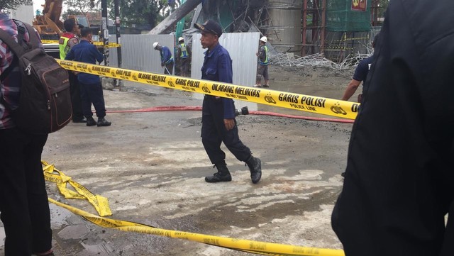 Petugas mulai pasang pembatas jalan di sisi-sisi penyangga tiang tol BORR yang ambruk. Foto: Lutfan Darmawan/kumparan