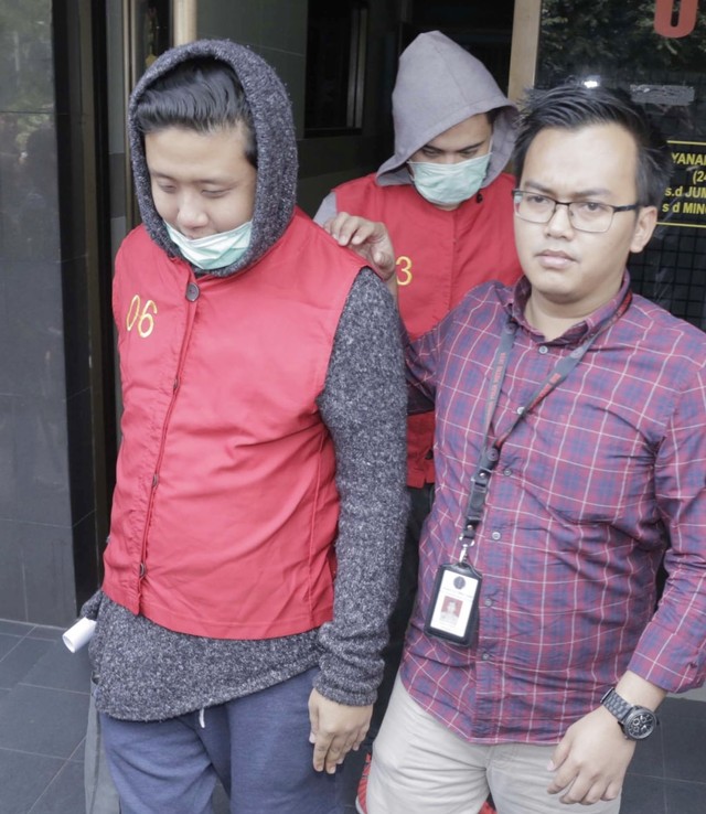 Pablo (kiri) dan Galih Ginanjar (tengah) saat dibawa anggota kepolisian di Polda Metro Jaya, Jakarta, Jumat, (12/7). Foto: Ronny