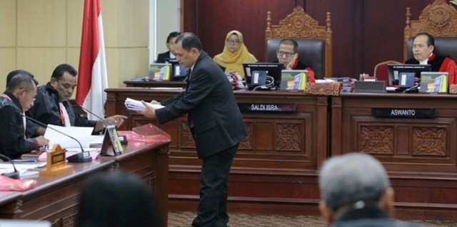 Petugas persidangan mengambil bukti tambahaan yang diserahkan kuasa hukum Partai Bulan Bintang, Anthoni Hatane dalam sidang perkara Perselisihan Hasil Pemilihan Umum (PHPU) DPR-DPRD 2019 Provinsi Maluku, Kamis (10/7). (Foto Humas MK)