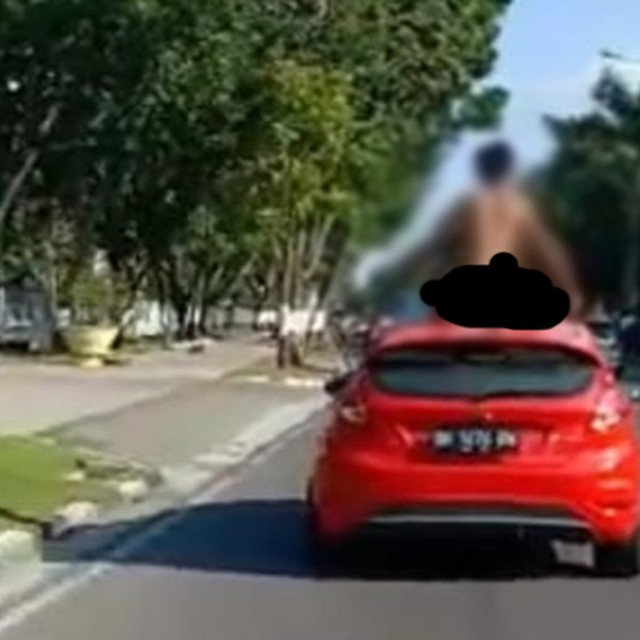 ORANG gila saat naik dan meloncat-loncar serta menari-nari di atas mobil dikendari dokter spesialis kandungan Metha Chlariza, Kamis, 11 Juli 2019, di Jalan Sudirman, Pekanbaru. 