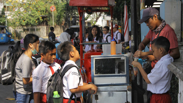 Sejumlah siswa sekolah dasar membeli makanan. Foto: Jamal Ramadhan/kumparan